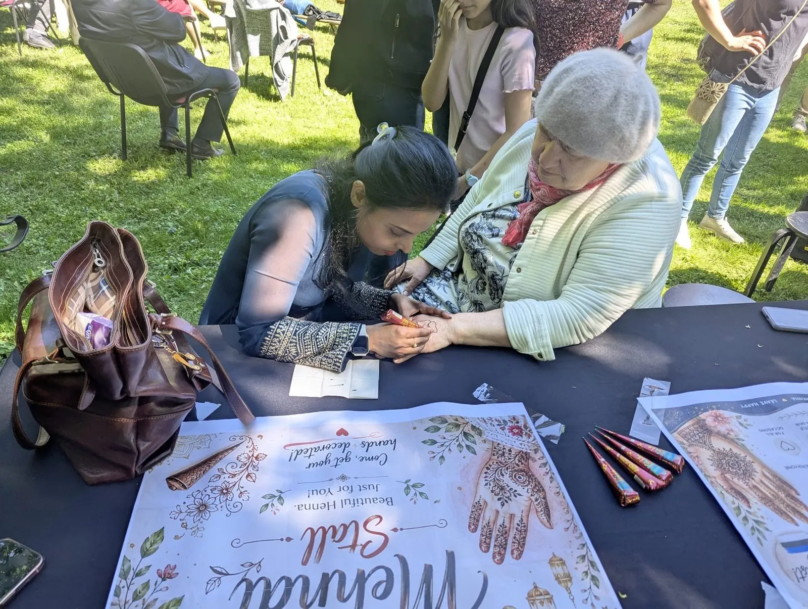 Vabatahtlik joonistab külalise käele mehendi mustri